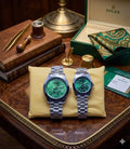 Rolex dupe couples watch set with green dials on stainless steel bracelets, shown with luxury packaging and presentation box.
