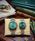 Rolex dupe gold and green dial couples watch set displayed on a cushion with vintage books and accessories