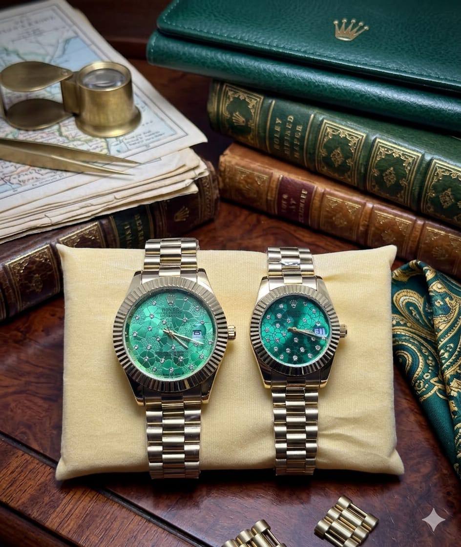 Rolex dupe gold and green dial couples watch set displayed on a cushion with vintage books and accessories